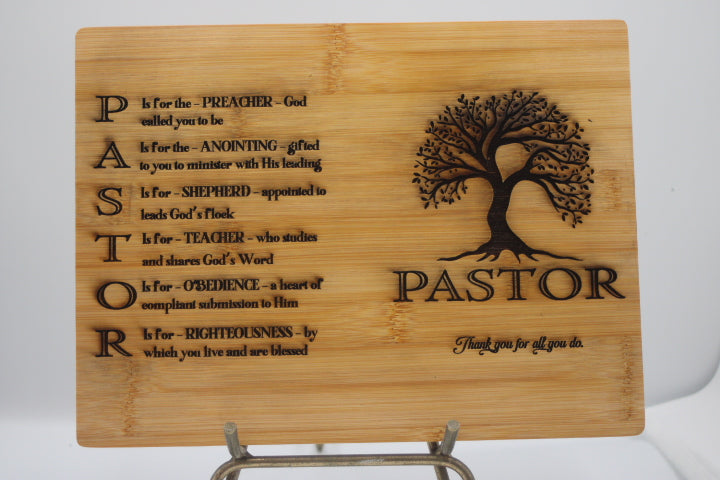 Wooden plaque with engraved text and tree design on a stand
